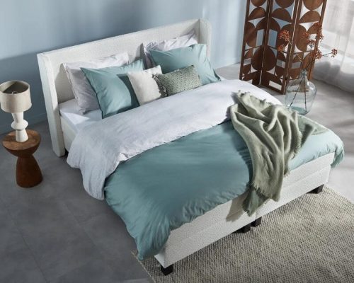 witte vol boxspring met teddy stof en vleugeltjes hoofdbord in lichtblauwe kamer